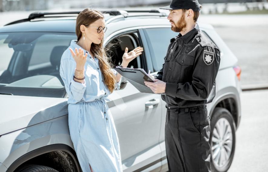 Femme se faisant verbaliser par un policier pour une infraction au Code de la route avec sa voiture