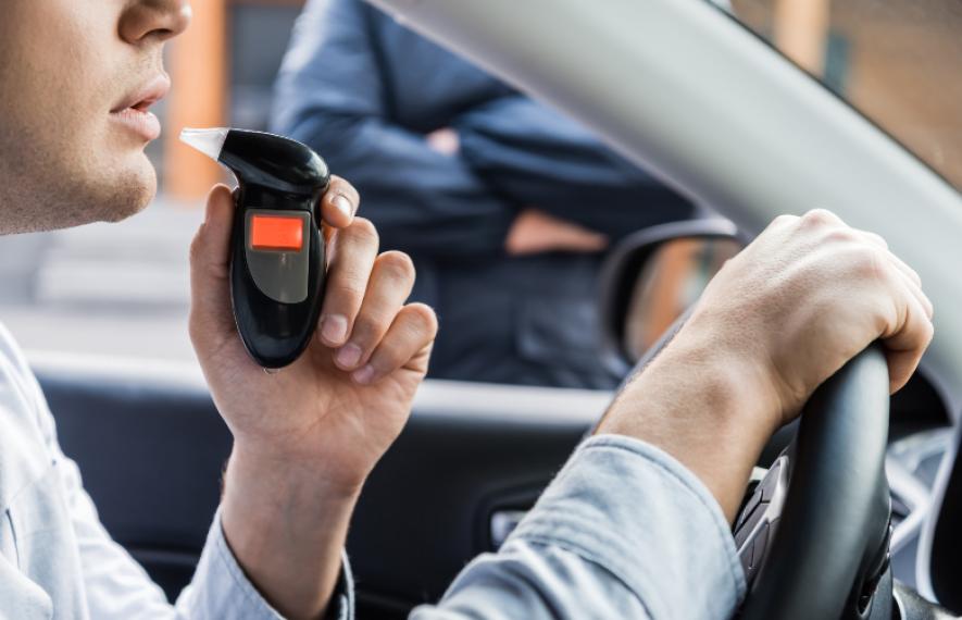 Homme au volant sur le point de mesurer son taux d'alcool