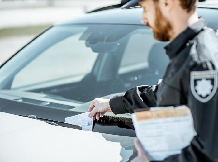 Agent posant une amende de stationnement sur le pare-brise d'une voiture - article amende de stationnement par Maître Franck Cohen