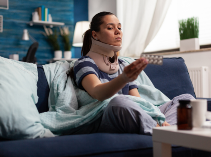 Femme après accident observant une plaquette de médicament contre stress post traumatique