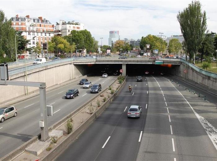 Autoroute urbaine avec un tunnel et un terre-plein central séparant les voies de circulation en sens opposé.
